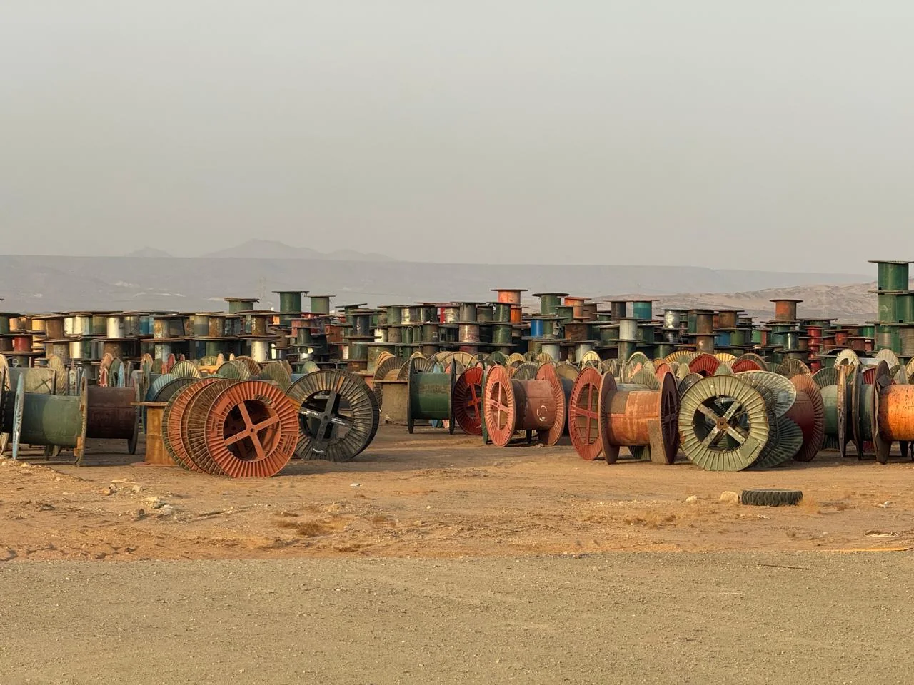Steel and wooden cable drums in an open yard